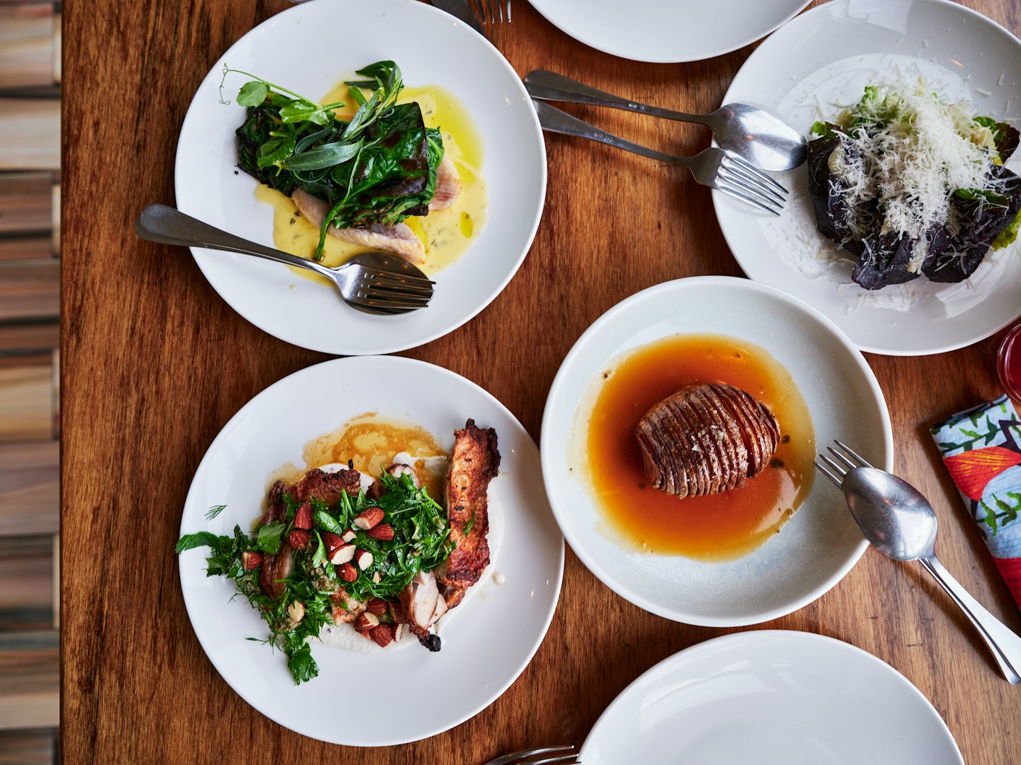 Gourmet dishes plated on a rustic wooden table.