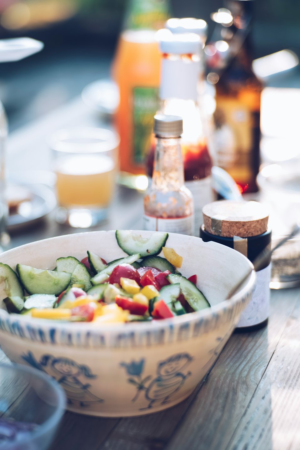 Fresh salad with cucumbers, tomatoes, and peppers in a rustic bowl.