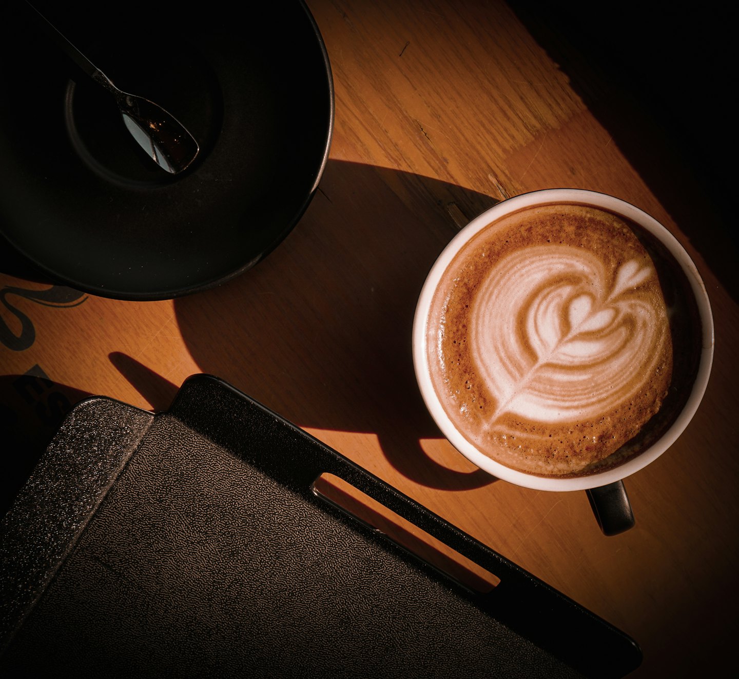 Latte art in a mug on a wooden table.