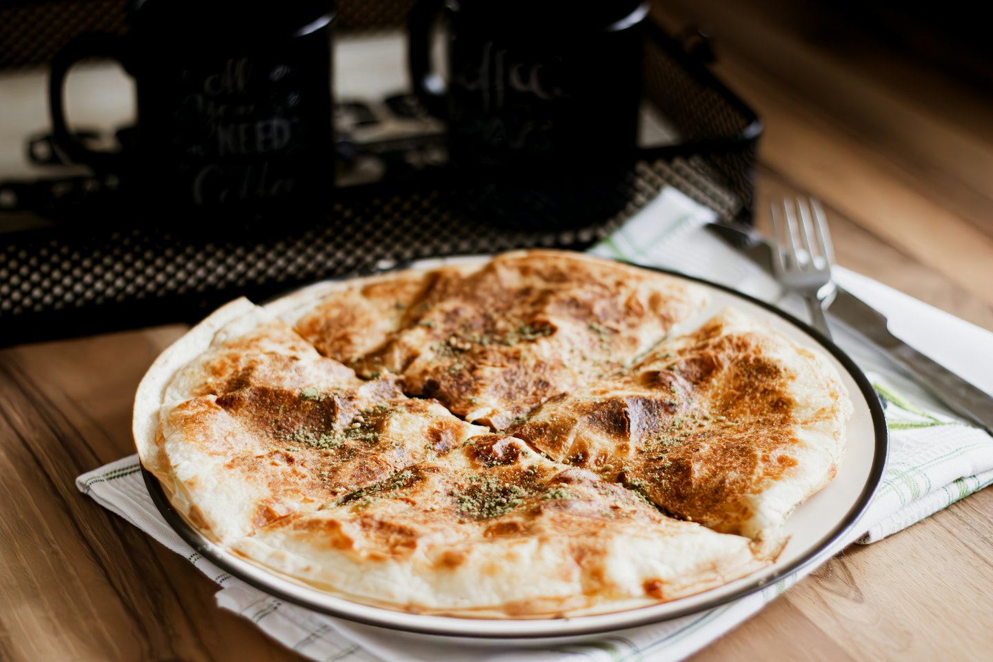 Sliced savory herb pastry on a plate atop a checkered napkin.